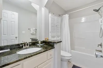a white bathroom with a sink and a toilet at Family Ready 3BR 2.5BA Home, Near Parks, Shops And Beach in Panama City Beach