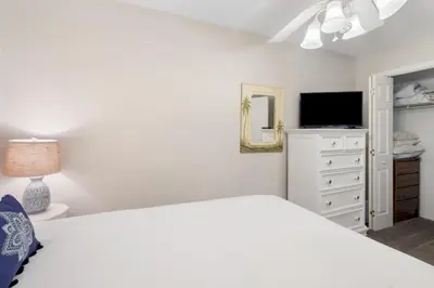 a white bedroom with a bed and a tv at Family Ready 3BR 2.5BA Home, Near Parks, Shops And Beach in Panama City Beach
