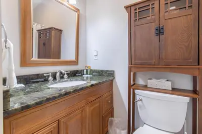 a bathroom with a sink and a toilet and a mirror at Family Ready 3BR 2.5BA Home, Near Parks, Shops And Beach in Panama City Beach