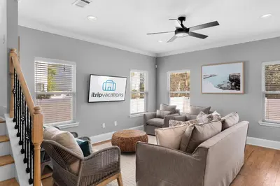 a living room with two chairs and a ceiling fan at Sunlit Sands in Inlet Beach