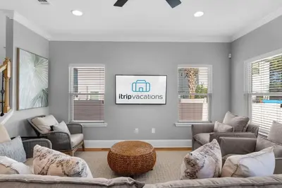 a living room with couches and a tv on the wall at Sunlit Sands in Inlet Beach