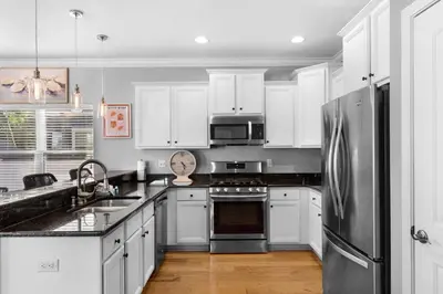 a kitchen with white cabinets and a stainless steel refrigerator at Sunlit Sands in Inlet Beach