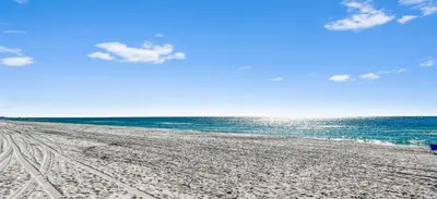 a beach with footprints in the sand and the ocean at Inlet Dunes 101 l Community Pool l Across From The Beach in Inlet Beach