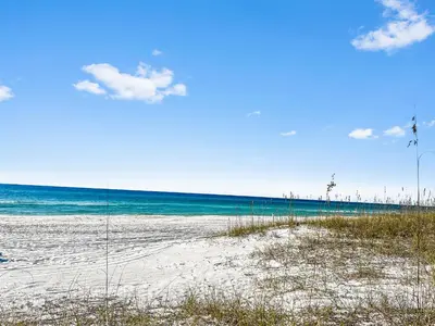 a beach with sand and the ocean on a sunny day at Inlet Dunes 101 l Community Pool l Across From The Beach in Inlet Beach