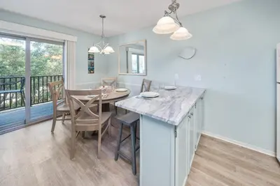 a kitchen and dining room with a table and chairs at Inlet Dunes 105 l Community Pool l Across From The Beach in Inlet Beach