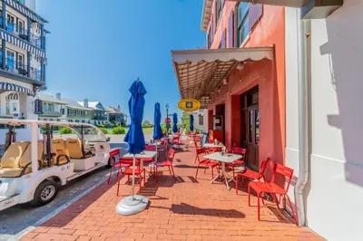 a patio with tables and chairs on a street at Inlet Dunes 105 l Community Pool l Across From The Beach in Inlet Beach