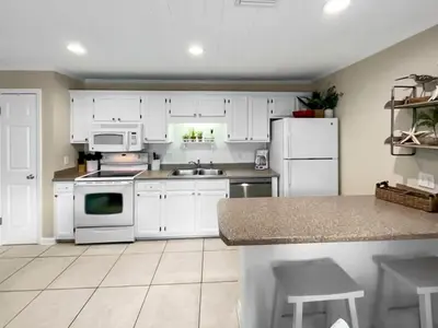 a kitchen with white cabinets and white appliances at Inlet Dunes 201 l Community Pool l Across From The Beach in Inlet Beach