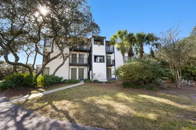 an apartment building with trees in front of it at Inlet Dunes 201 l Community Pool l Across From The Beach in Inlet Beach