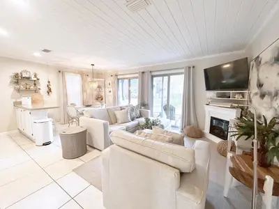 a living room with white furniture and a fireplace at Inlet Dunes 201 l Community Pool l Across From The Beach in Inlet Beach