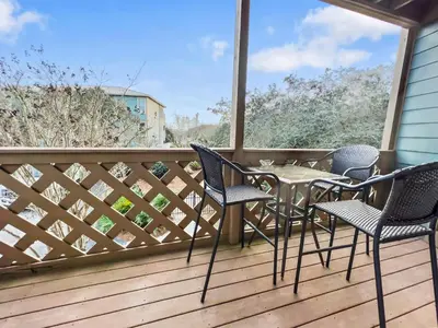 a patio with chairs and a table on a deck at Inlet Dunes 204 l Community Pool l Across From The Beach in Inlet Beach