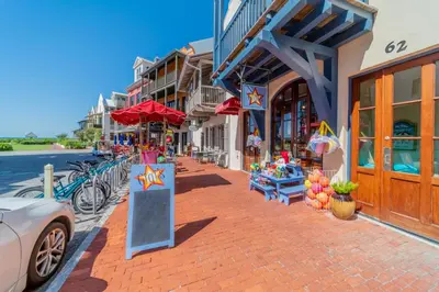 a street with shops and a car parked on a sidewalk at Inlet Dunes 204 l Community Pool l Across From The Beach in Inlet Beach