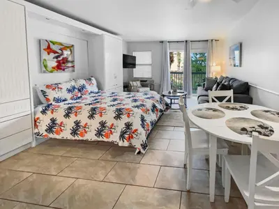 a living room with a bed and a dining table at Inlet Sands 204 l 1 min walk to beach l Community Pool l Bike to Rosemary in Inlet Beach