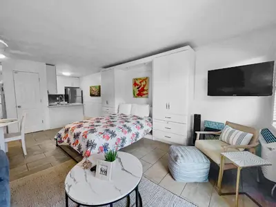a bedroom with a bed and a living room at Inlet Sands 204 l 1 min walk to beach l Community Pool l Bike to Rosemary in Inlet Beach