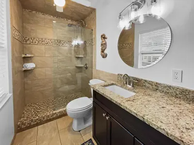 a bathroom with a toilet and a sink and a mirror at Inlet Sands 204 l 1 min walk to beach l Community Pool l Bike to Rosemary in Inlet Beach