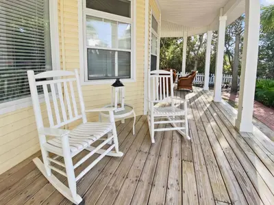 two white rocking chairs sitting on a porch at Keylime Pie l Heated Pool l 2 min walk to beach l 6 seater golf cart and 4 bikes included in Inlet Beach