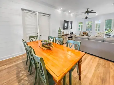 a dining room with a wooden table and chairs at Keylime Pie l Heated Pool l 2 min walk to beach l 6 seater golf cart and 4 bikes included in Inlet Beach