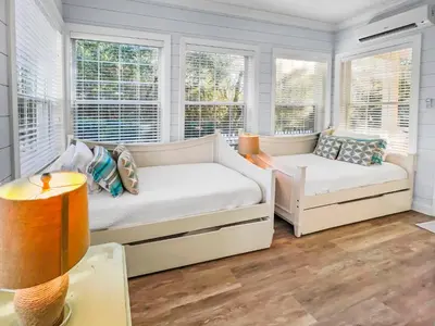a bedroom with two beds and two windows at Keylime Pie l Heated Pool l 2 min walk to beach l 6 seater golf cart and 4 bikes included in Inlet Beach