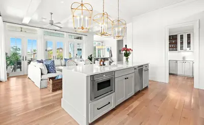 a kitchen with a white counter top and a living room at Pomp in Paradise in Inlet Beach