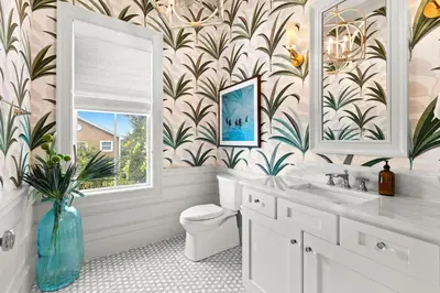 a bathroom with a toilet and a sink and a window at Pomp in Paradise in Inlet Beach
