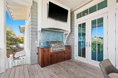 a screened porch with a television and a grill on a house at Pomp in Paradise in Inlet Beach