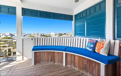 a bench on a balcony with a view of the ocean at Pomp in Paradise in Inlet Beach