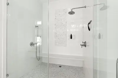 a white bathroom with a shower with a glass door at Pomp in Paradise in Inlet Beach