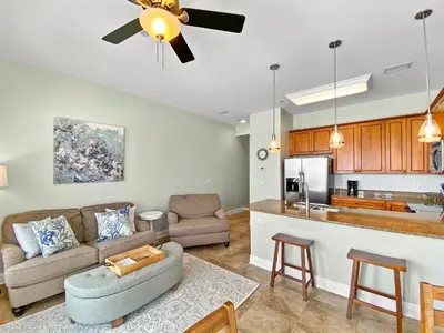 a living room and kitchen with a couch and a ceiling fan at Leeward 1 7 l Beachfront Condo with Stunning Views of the Water l Bike to Seaside in Seagrove Beach