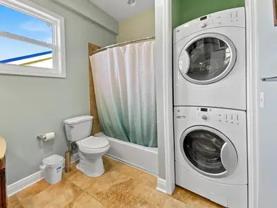 a bathroom with a washing machine and a toilet at Leeward 1 7 l Beachfront Condo with Stunning Views of the Water l Bike to Seaside in Seagrove Beach