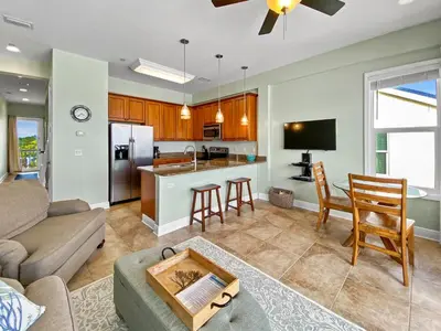 a living room with a couch and a kitchen at Leeward 1 7 l Beachfront Condo with Stunning Views of the Water l Bike to Seaside in Seagrove Beach