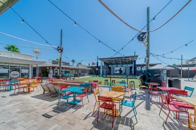 a group of tables and chairs in a patio at Leeward 1 7 l Beachfront Condo with Stunning Views of the Water l Bike to Seaside in Seagrove Beach