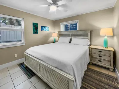 a bedroom with a large bed and two windows at Leeward II 3 l Beachfront Condo l Large first level deck with steps down to sand in Seagrove Beach