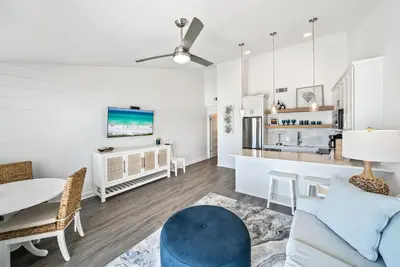 a living room with white walls and a blue couch at Leeward II 8 Sand Angels l Beachfront Condo l Newly Renovated l Beach Towels in Seagrove Beach