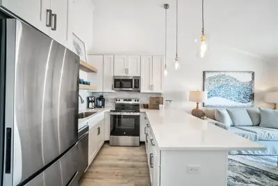 a kitchen with white cabinets and a blue couch at Leeward II 8 Sand Angels l Beachfront Condo l Newly Renovated l Beach Towels in Seagrove Beach