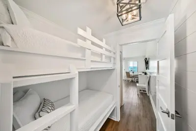 a bedroom with white bunk beds and a desk at Leeward II 8 Sand Angels l Beachfront Condo l Newly Renovated l Beach Towels in Seagrove Beach
