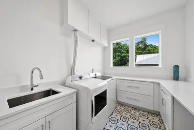 a white kitchen with a sink and a window at Magnolia Tides l 6 Bedroom l Private Pool l South of 30A l Santa Rosa Beach in Santa Rosa Beach