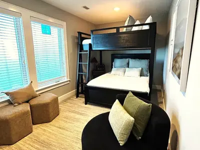 a bedroom with a bunk bed and a couch at Nifty Shades of Gray l Beachfront and panoramic Views l Fire pit beachside l 4 Bikes in Inlet Beach