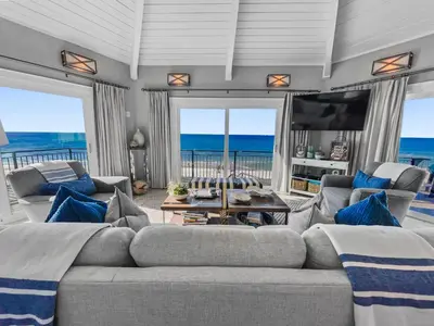 a living room with a couch and a tv and the ocean at Nifty Shades of Gray l Beachfront and panoramic Views l Fire pit beachside l 4 Bikes in Inlet Beach