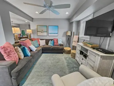 a living room with a couch and a flat screen tv at Nifty Shades of Gray l Beachfront and panoramic Views l Fire pit beachside l 4 Bikes in Inlet Beach