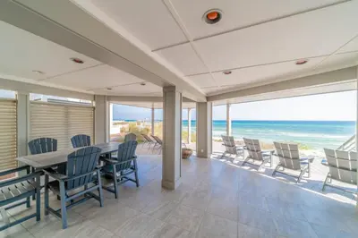 a dining room with a table and chairs and the ocean at Nifty Shades of Gray l Beachfront and panoramic Views l Fire pit beachside l 4 Bikes in Inlet Beach