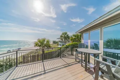 a balcony with a table and a view of the ocean at Nifty Shades of Gray l Beachfront and panoramic Views l Fire pit beachside l 4 Bikes in Inlet Beach