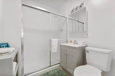a white bathroom with a toilet and a shower at 19224 Delmar Dr in Panama City Beach