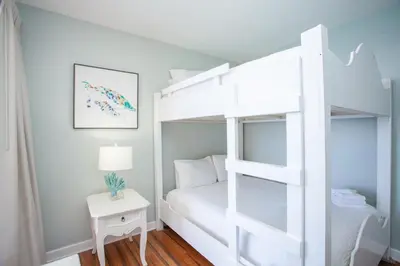 a white bunk bed in a white room with a table at Splash 1701E - 2BD in Panama City Beach