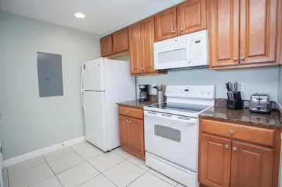 a kitchen with white appliances and wooden cabinets at Splash 1701E in Panama City Beach