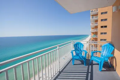 two blue chairs sitting on a balcony looking at the ocean at Splash 1701E in Panama City Beach