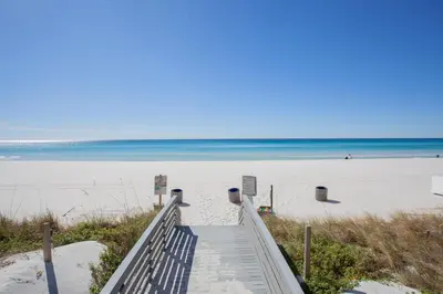 a stairway leading to a sandy beach with the ocean at Splash 1701E - Studio in Panama City Beach