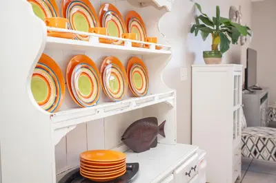 a shelf filled with plates and bowls in a kitchen at Splash 504E in Panama City Beach