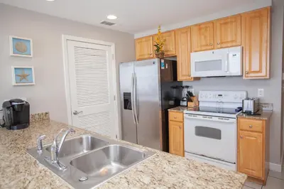 a kitchen with a sink and a stainless steel refrigerator at Splash 504E in Panama City Beach