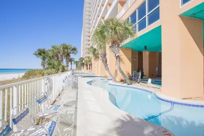 a resort swimming pool with chairs and the beach at Splash 504E in Panama City Beach