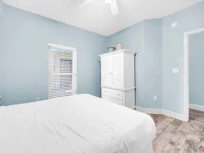 a bedroom with a white bed and blue walls at Majestic Beach Towers One 1314 by Emerald Coast Retreats in Panama City Beach