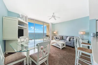 a living room with a glass table and a couch at Majestic Beach Towers One 1314 by Emerald Coast Retreats in Panama City Beach